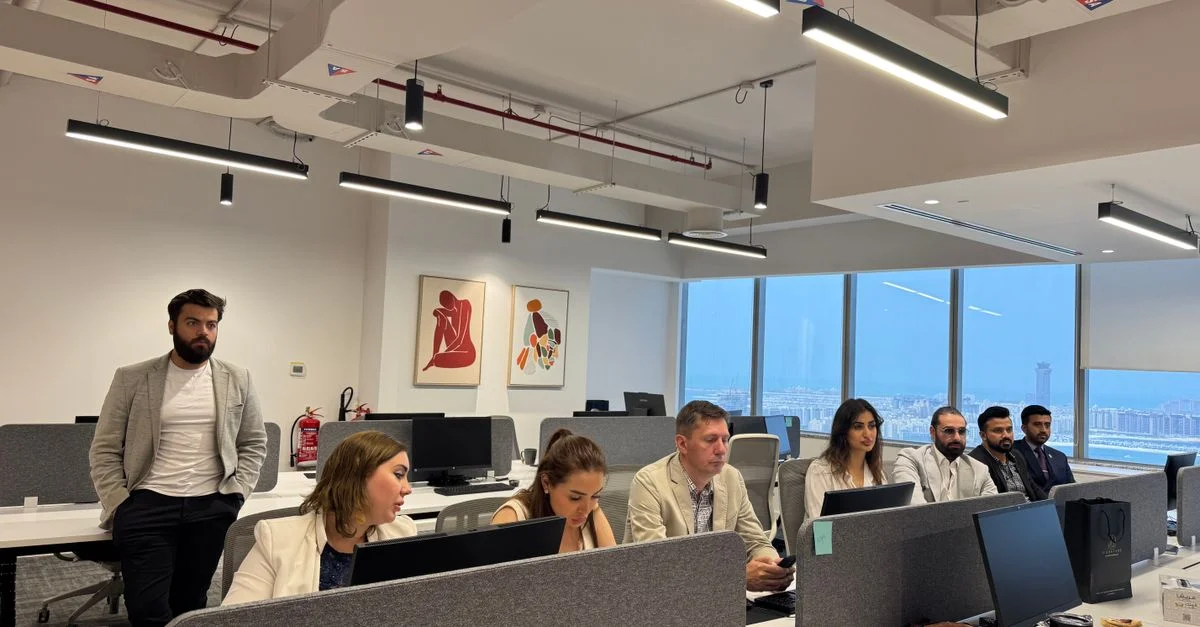 Profesionales trabajando en un entorno de oficina moderno, colaborando y discutiendo temas de negocios.