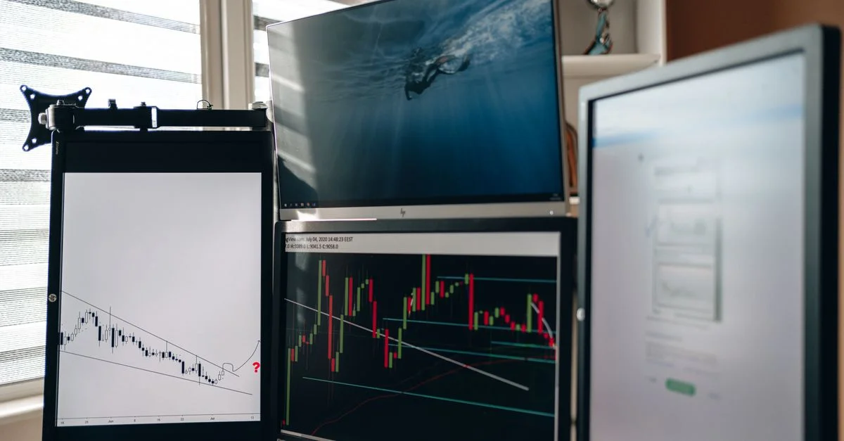 Una oficina en casa con múltiples monitores que muestran gráficos de trading y análisis de datos.