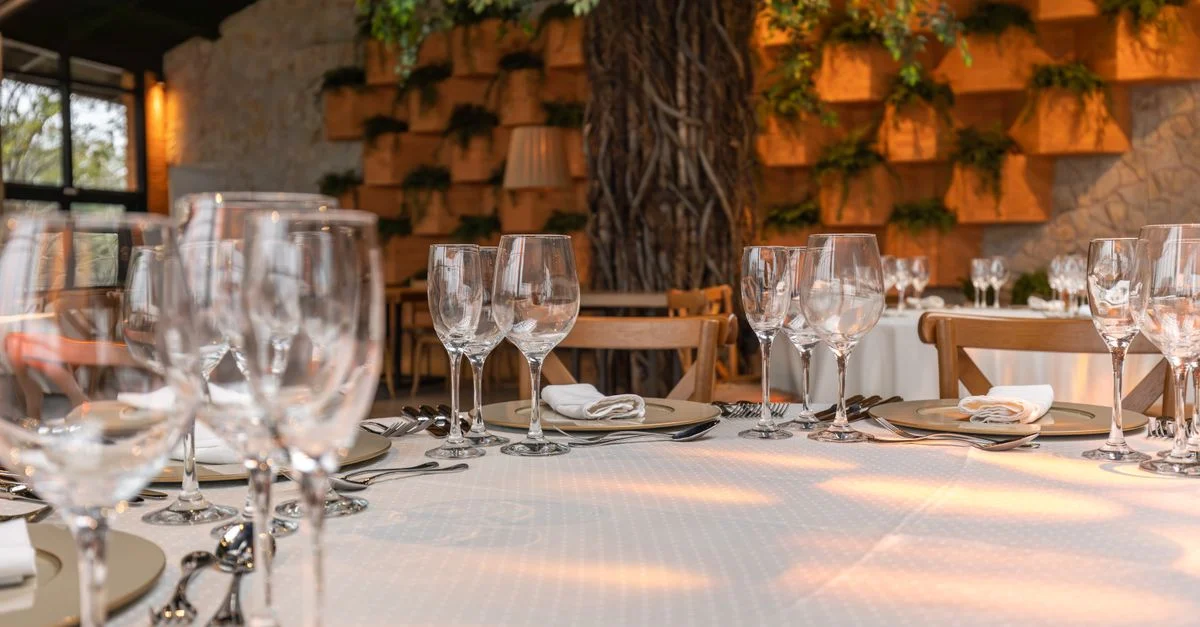 Elegante decoración de mesa en un restaurante con copas de vino y decoración estilosa.
