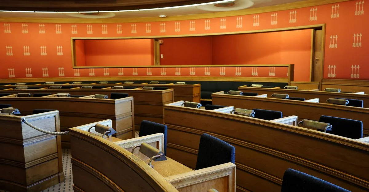 Una sala de reuniones parlamentaria vacía con asientos de madera y paredes de color naranja vibrante en Oslo, Noruega.