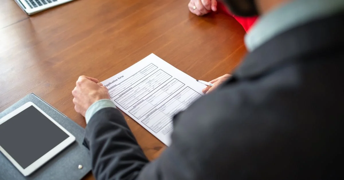 Profesionales de negocios revisando un formulario de solicitud durante una reunión.