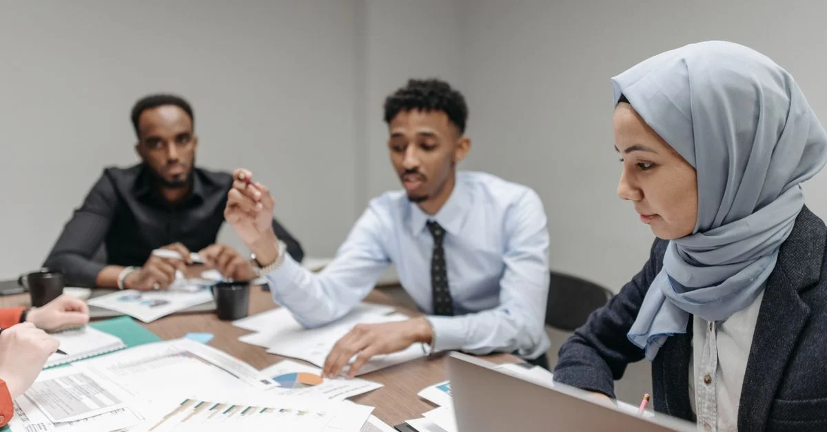Un equipo multicultural involucrado en una reunión de oficina productiva, discutiendo estrategias empresariales.