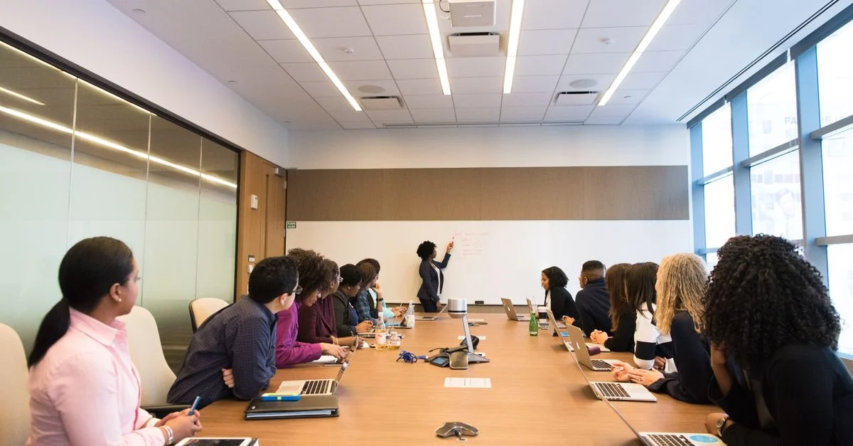 Reunión de negocios con un equipo diverso discutiendo proyectos en una sala de conferencias moderna.