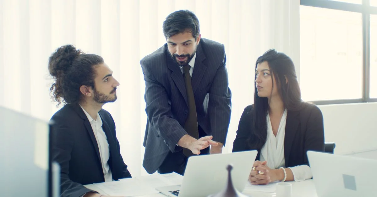 Equipo profesional en la oficina discutiendo un proyecto empresarial con colaboración enfocada.