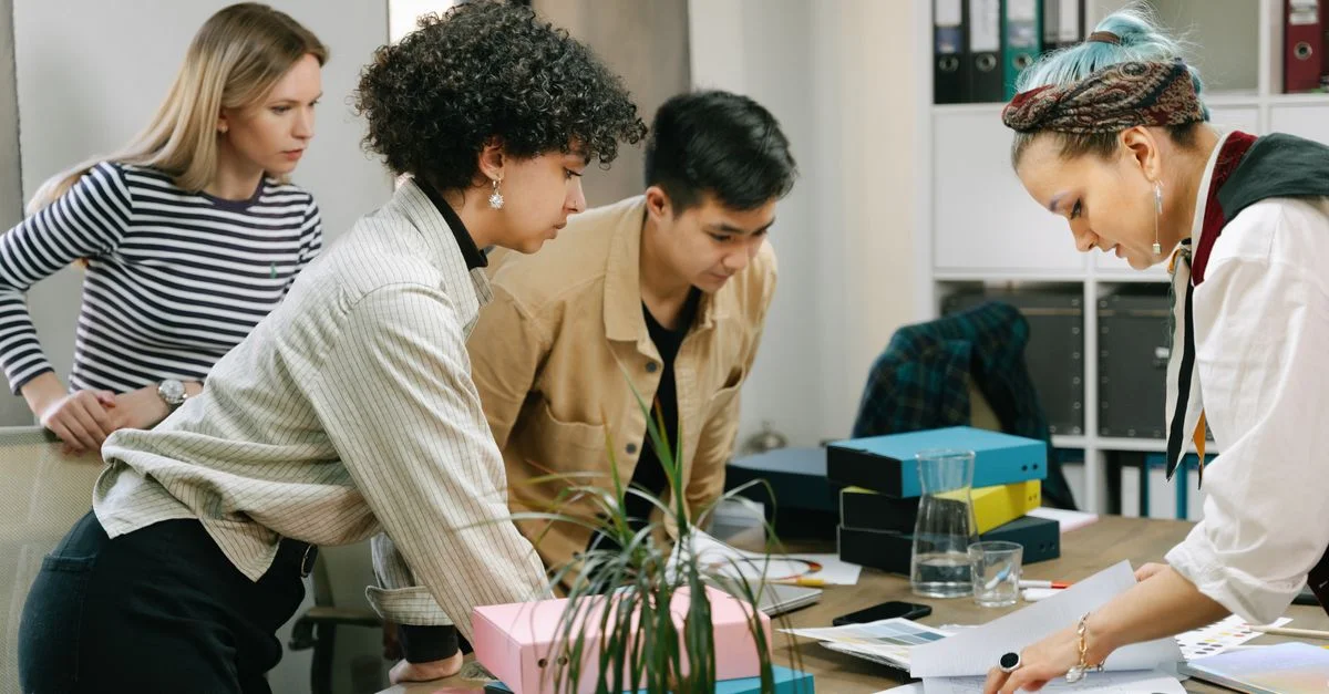 Un equipo diverso de colegas colaborando en un proyecto empresarial en un entorno de oficina moderna.