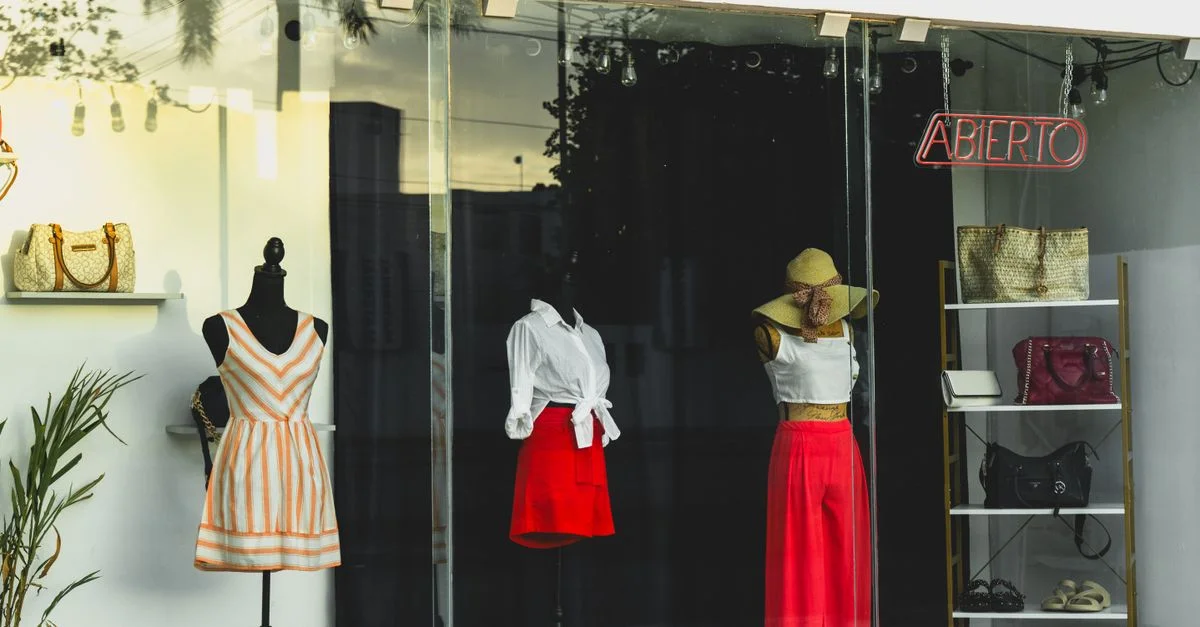 Maniquíes de moda en un elegante escaparate de boutique al atardecer en Mérida, Yucatán.