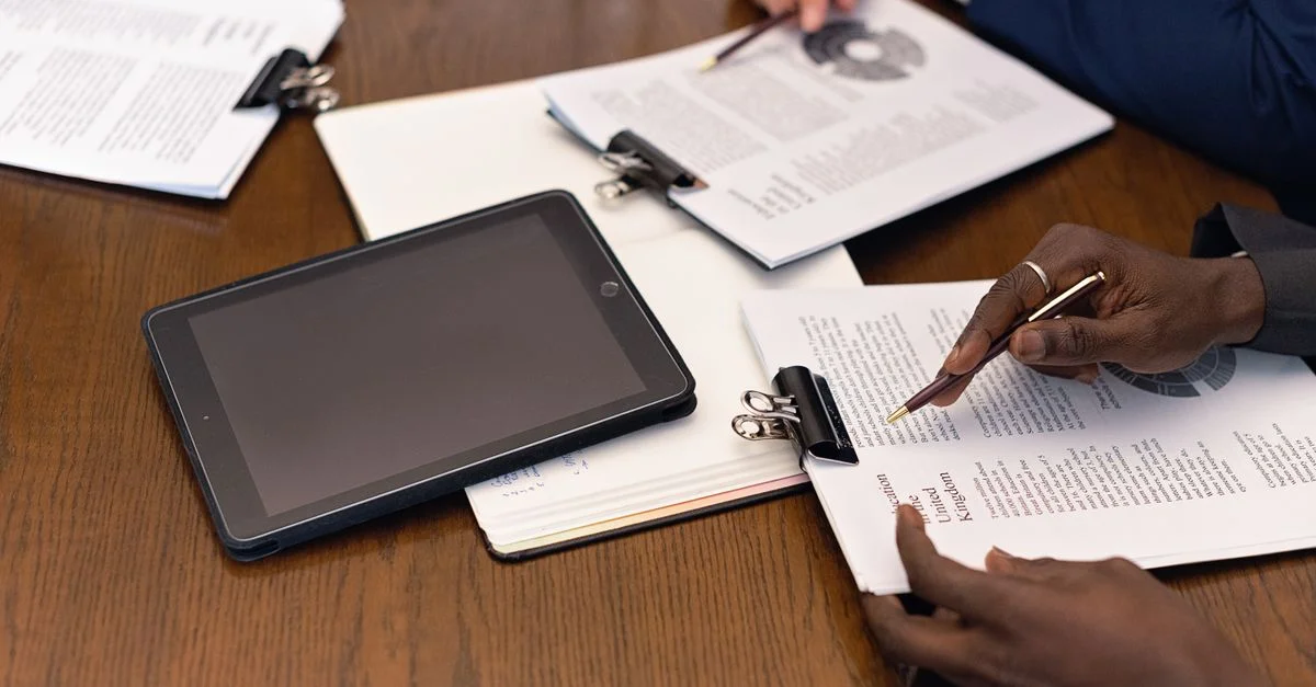 Una reunión de negocios con tabletas y documentos, que muestra la integración digital en un entorno profesional.